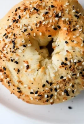 Freshly baked protein bagels stacked on a wooden board