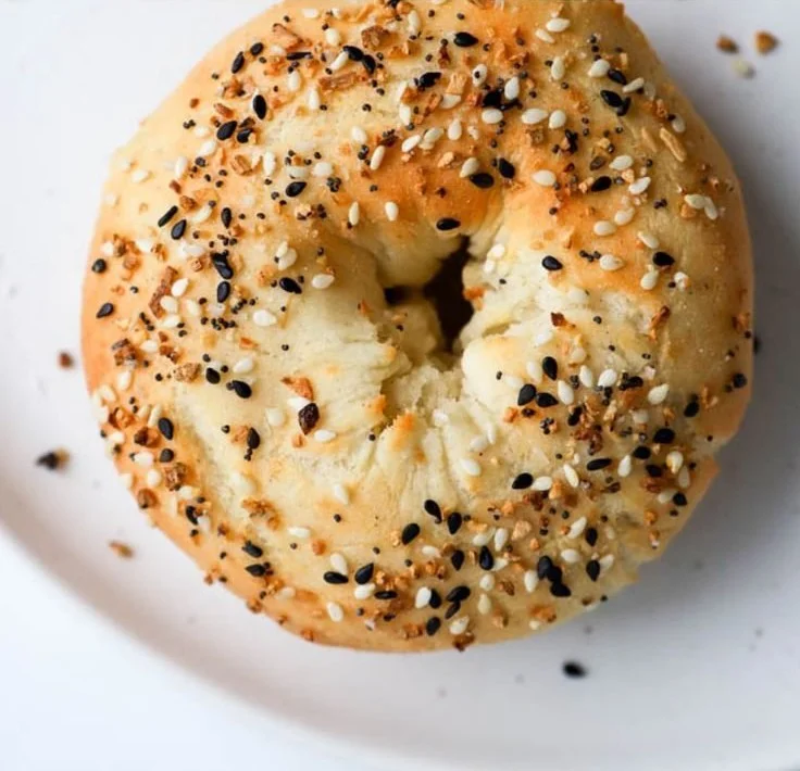 Freshly baked protein bagels stacked on a wooden board