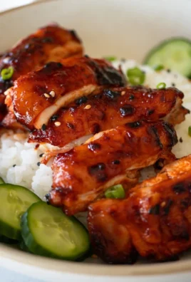 Sticky Honey Gochujang Chicken garnished with sesame seeds and green onions.