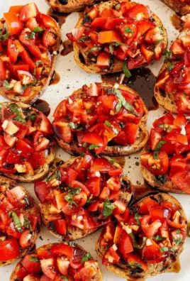 Plate of fresh tomato and basil bruschetta garnished with herbs.
