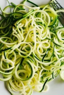 Healthy zucchini noodles served with fresh vegetables and sauce